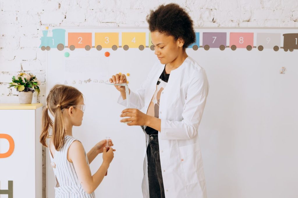 The Art of Drawing Readers In: Your attractive post title goes here A teacher guides a child through a fun and educational science experiment in a classroom setting.